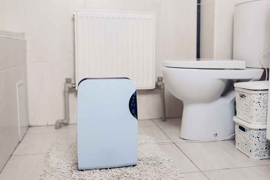 Dehumidifier installed in a bathroom for unrestricted airflow.