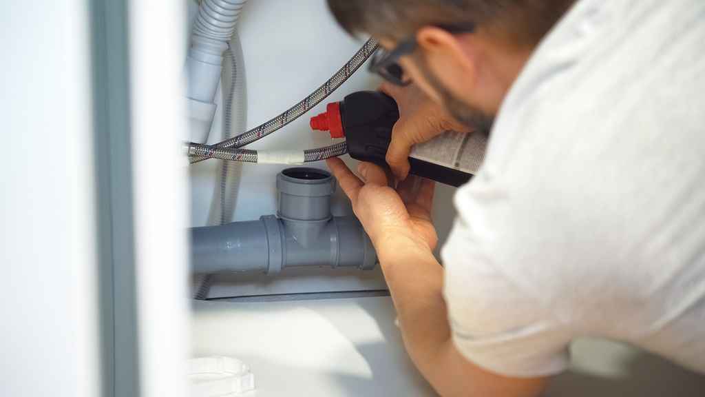 Man fixing blocked sewer pipes in the bathroom sink. Removing blockage clog in drain pipe.