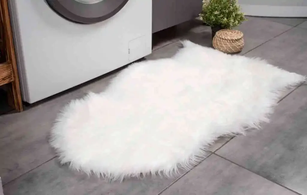 Bathroom mat placed on the ground in front of a washing machine to be washed
