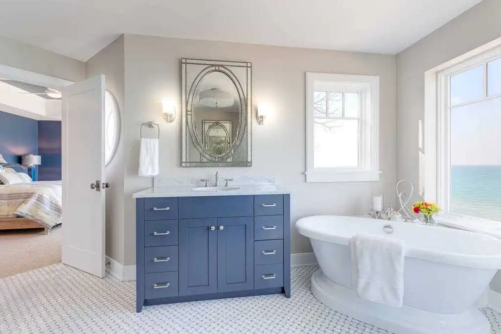 Coastal blue bathroom vanity ideas with a freestanding tub and a wall mirror