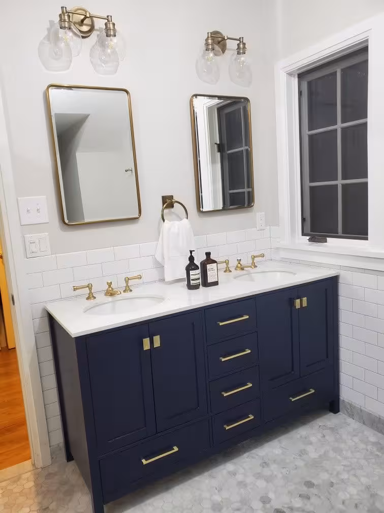 Dark blue bathroom vanity with brass hardware looking sophiscated and luxurious.
