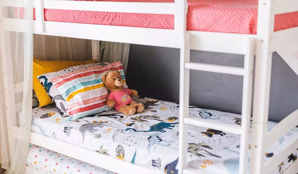 Design ideas for kids bedroom, showcasing colorful beddings and a toy laying on the mattress