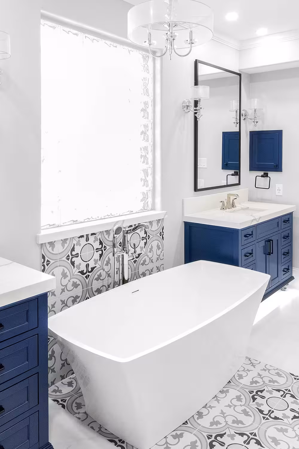 Mediterranean style navy blue bathroom design with a freestanding tub and two navy blue cabinets