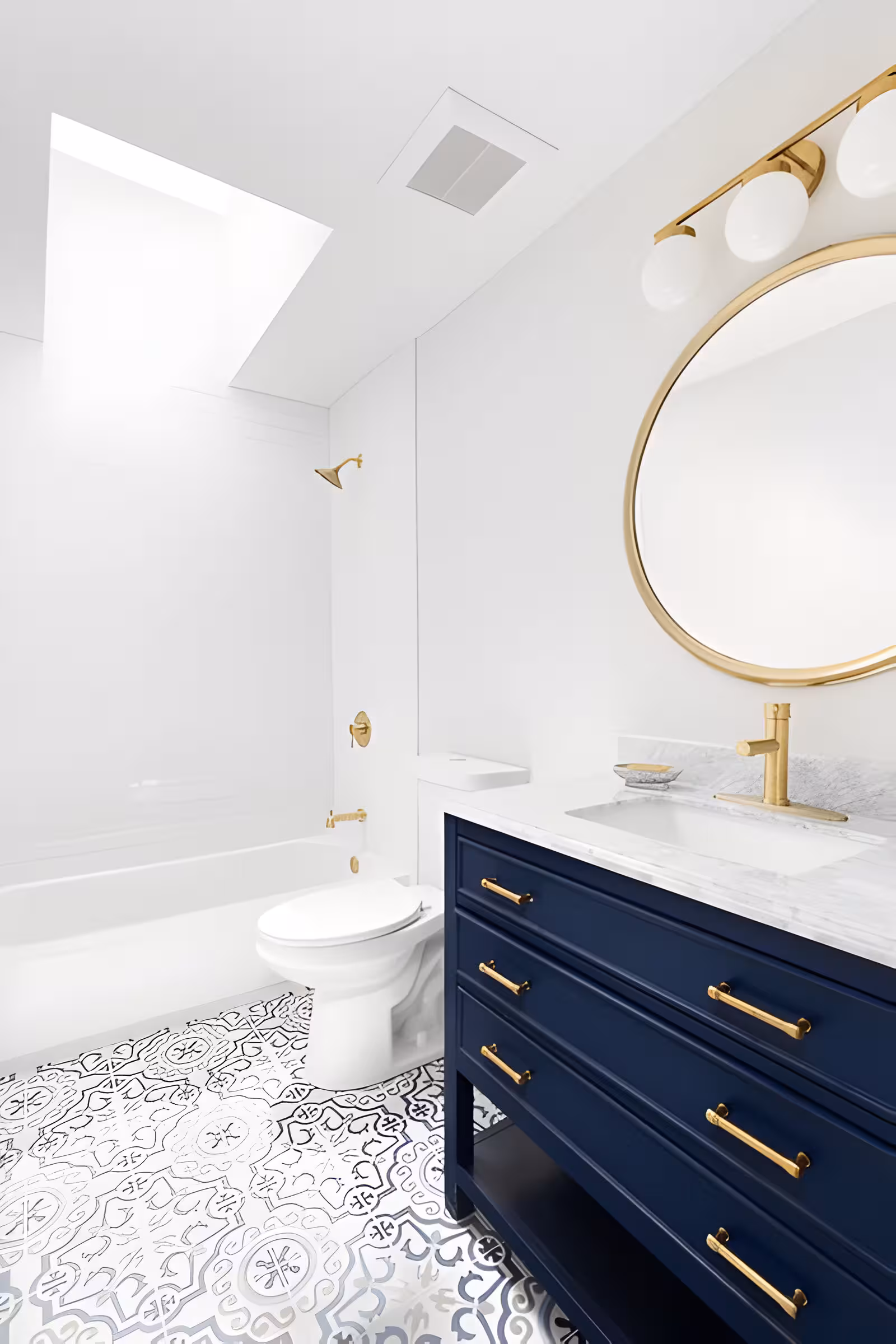 A navy blue bathroom vanity with gold hardware including a wall mirror and a water system