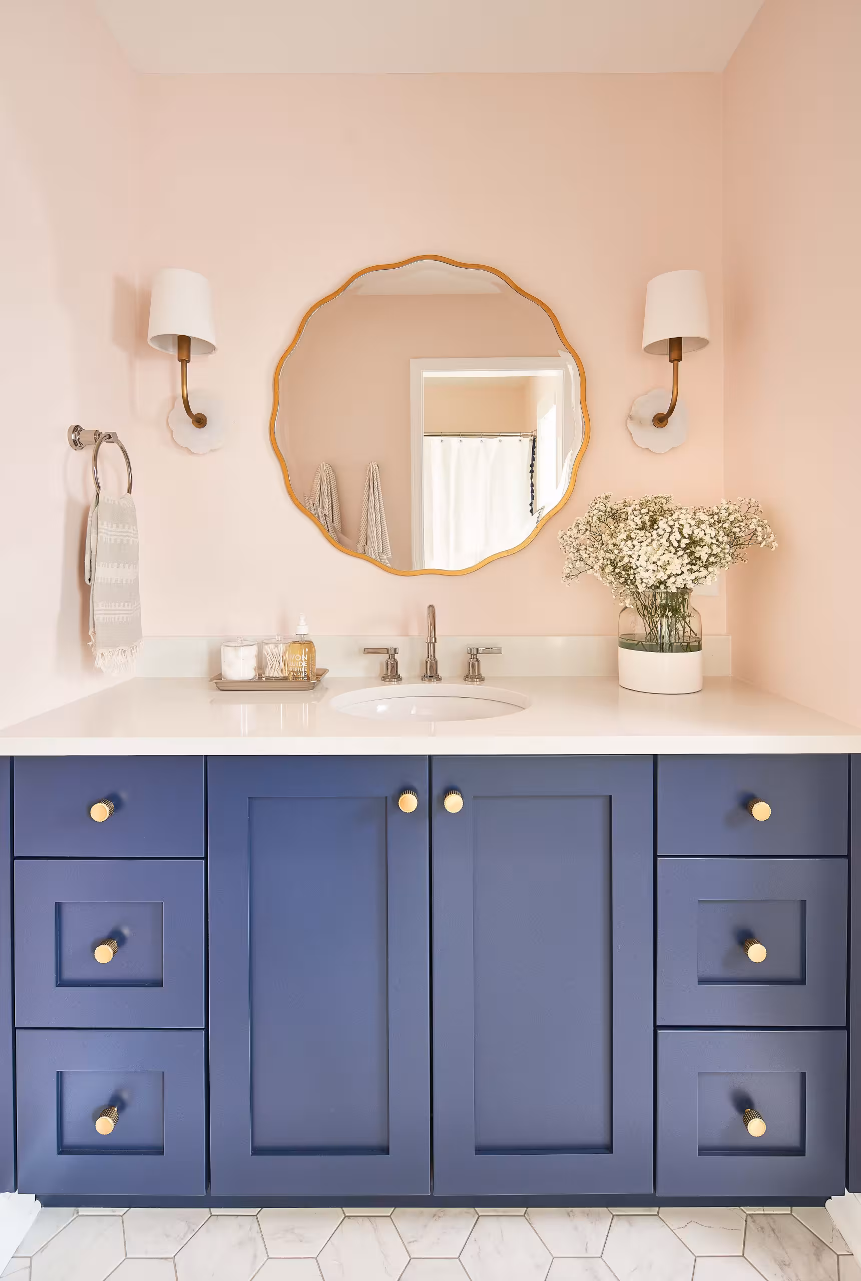 Blue bathroom vanity in a pink painted bathroom wall
