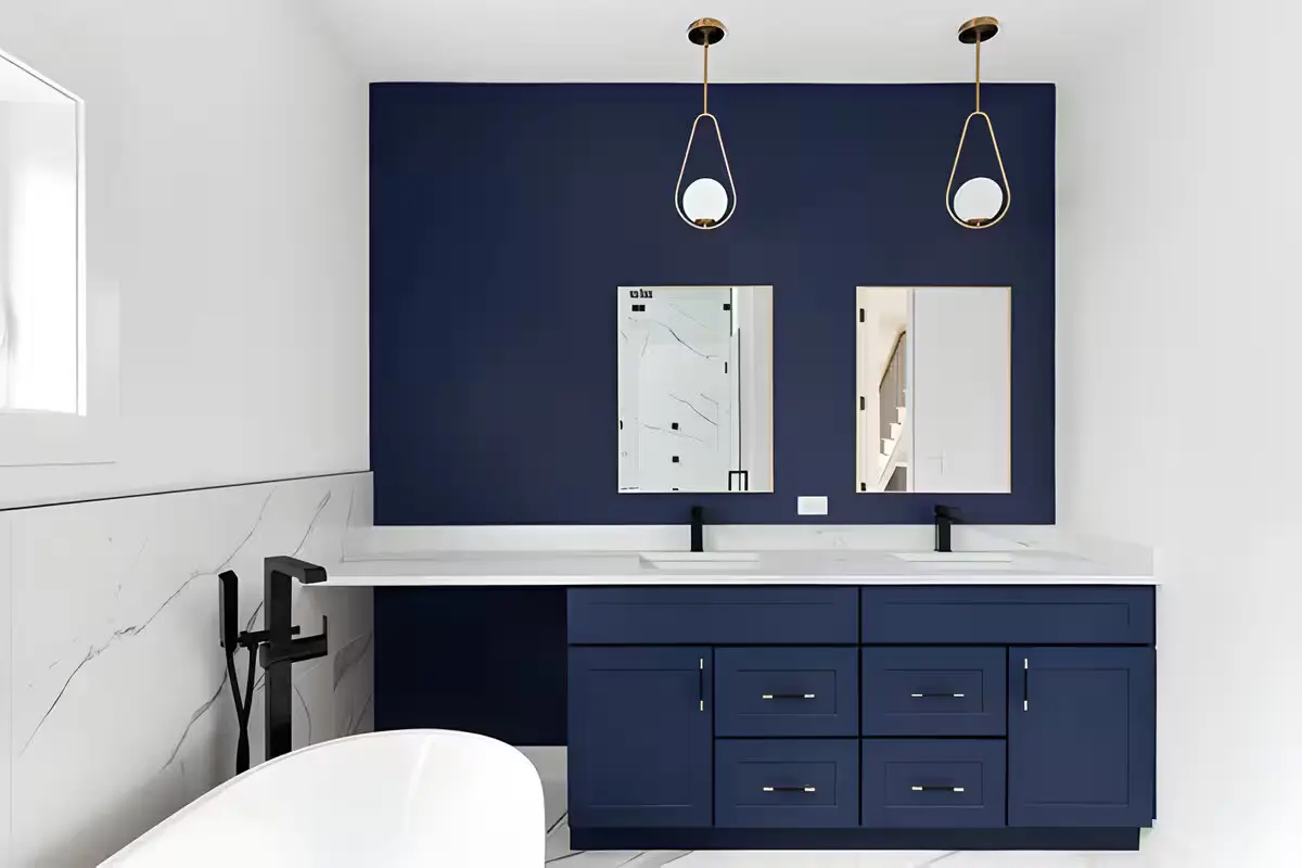 Blue vanity bathroom ideas in a white bathroom walls featuring a freestanding tub and two lights in the ceiling.