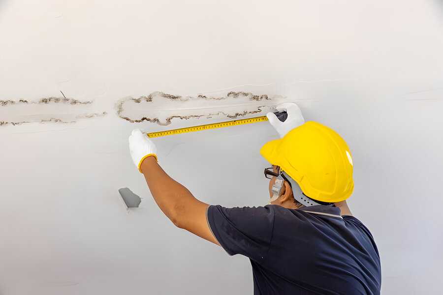 Man fixing water leak on his bathroom  ceiling