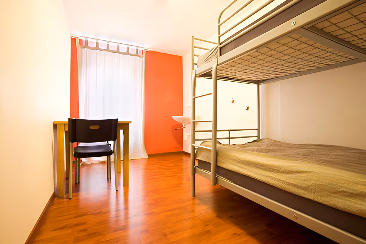A. bedroom with a twin over twin bunk bed showcasing the bedroom dimension, a desk, and a chair