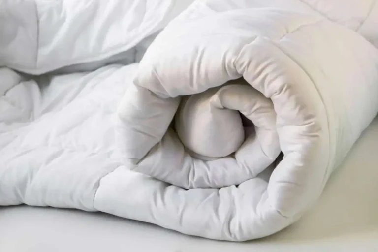 A folded comforter displaying a partial measurement of a king size comforter